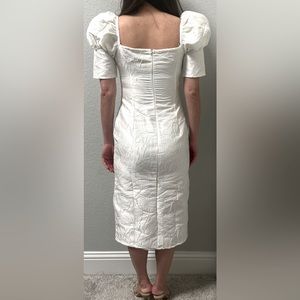 A white midi dress with puffed sleeves
